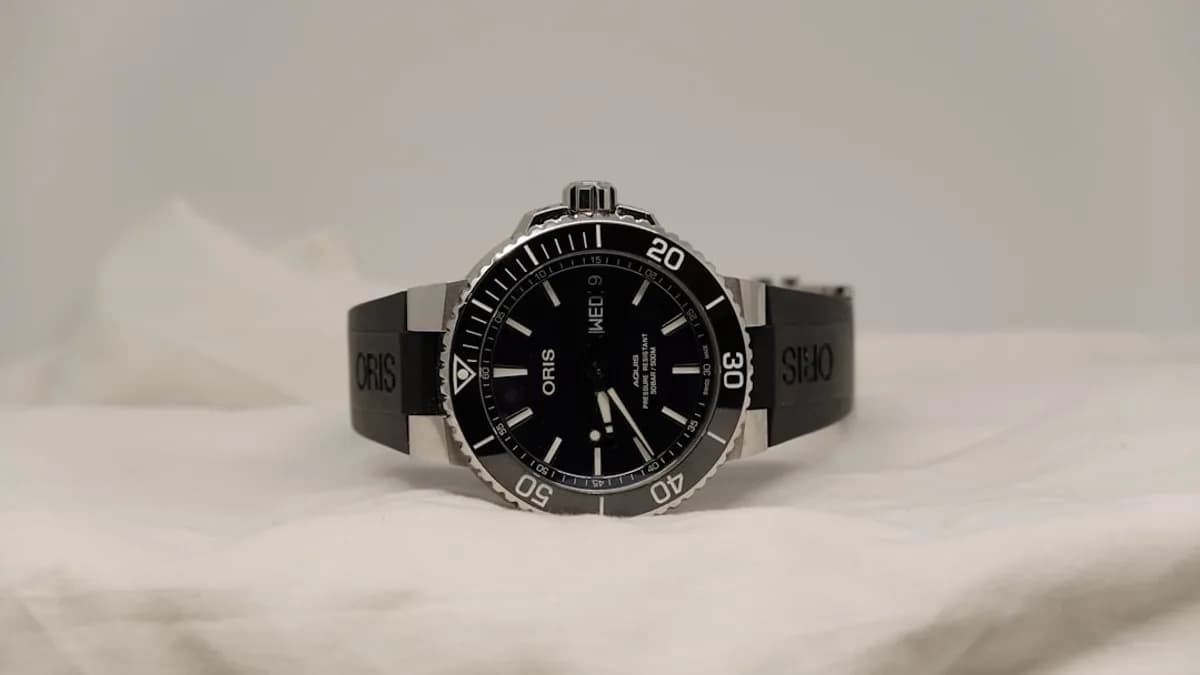 a watch sitting on top of a white sheet