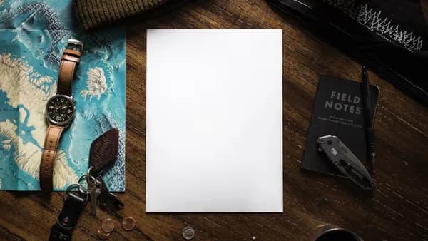 a notepad sitting on top of a wooden table next to a pair of scissors