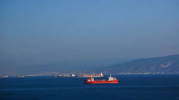 A large red boat floating on top of a large body of water