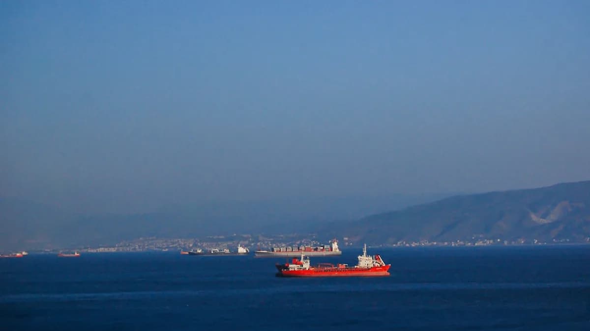 A large red boat floating on top of a large body of water