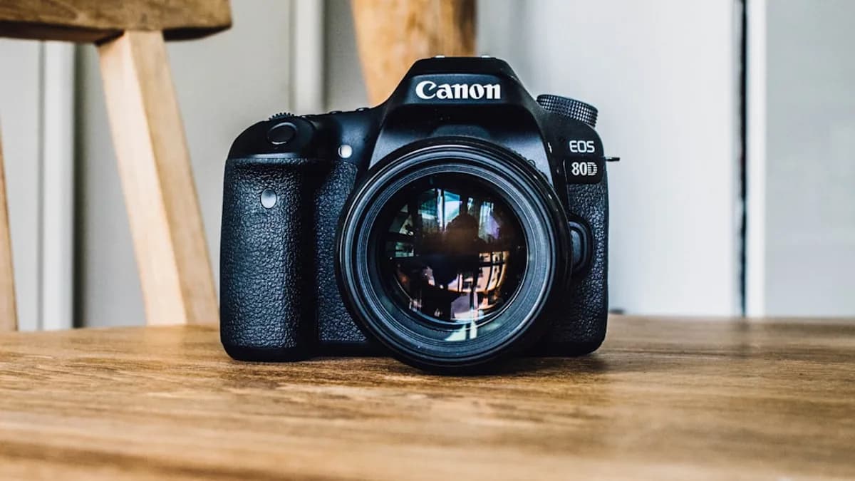 Canon DSLR camera on brown wooden table during daytime