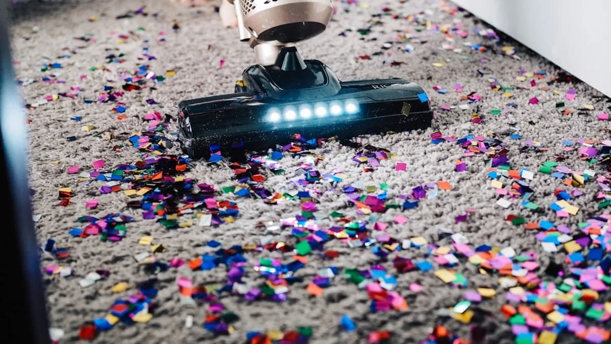 a person using a vacuum to clean a carpet